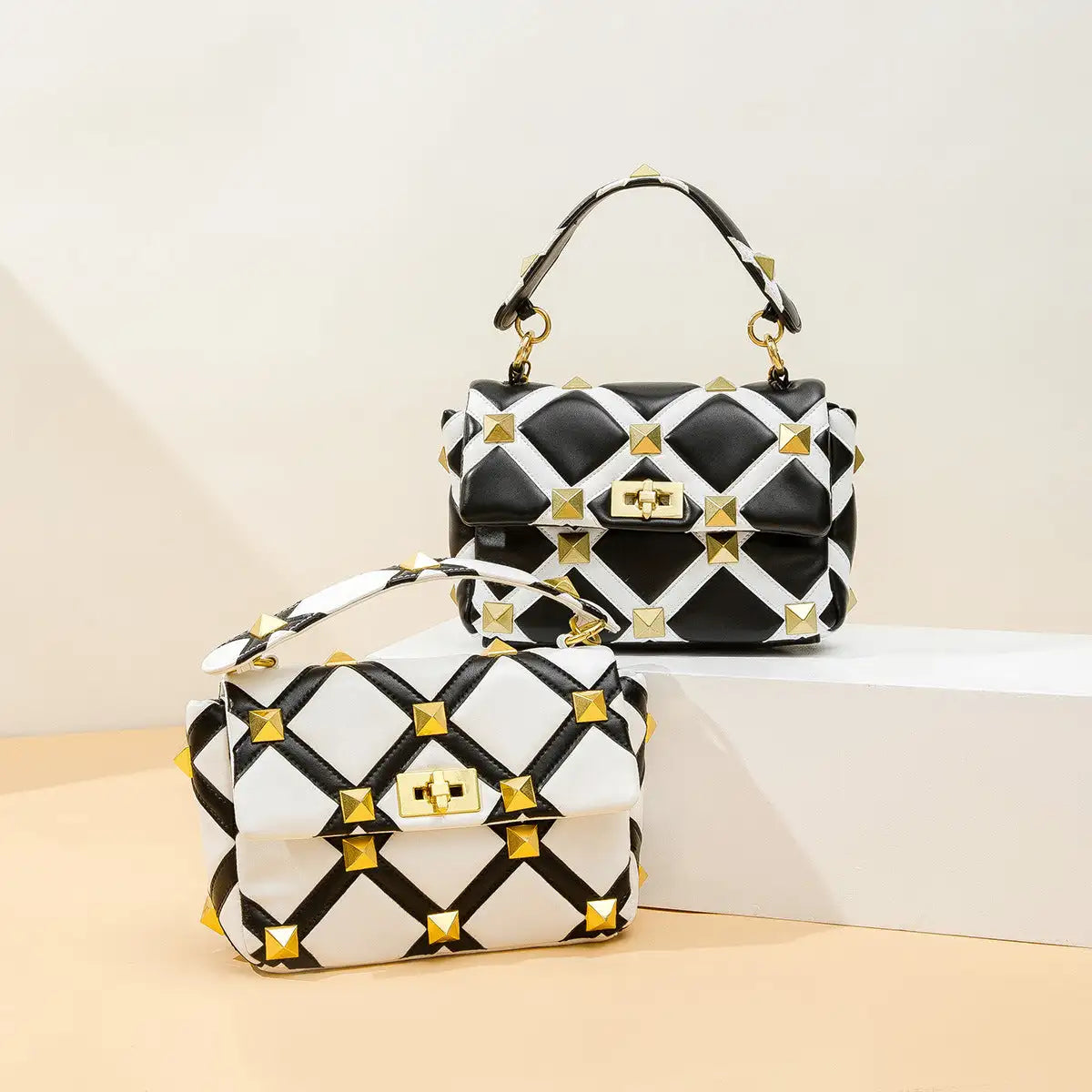 Black and white quilted handbag with gold studs, textured material.