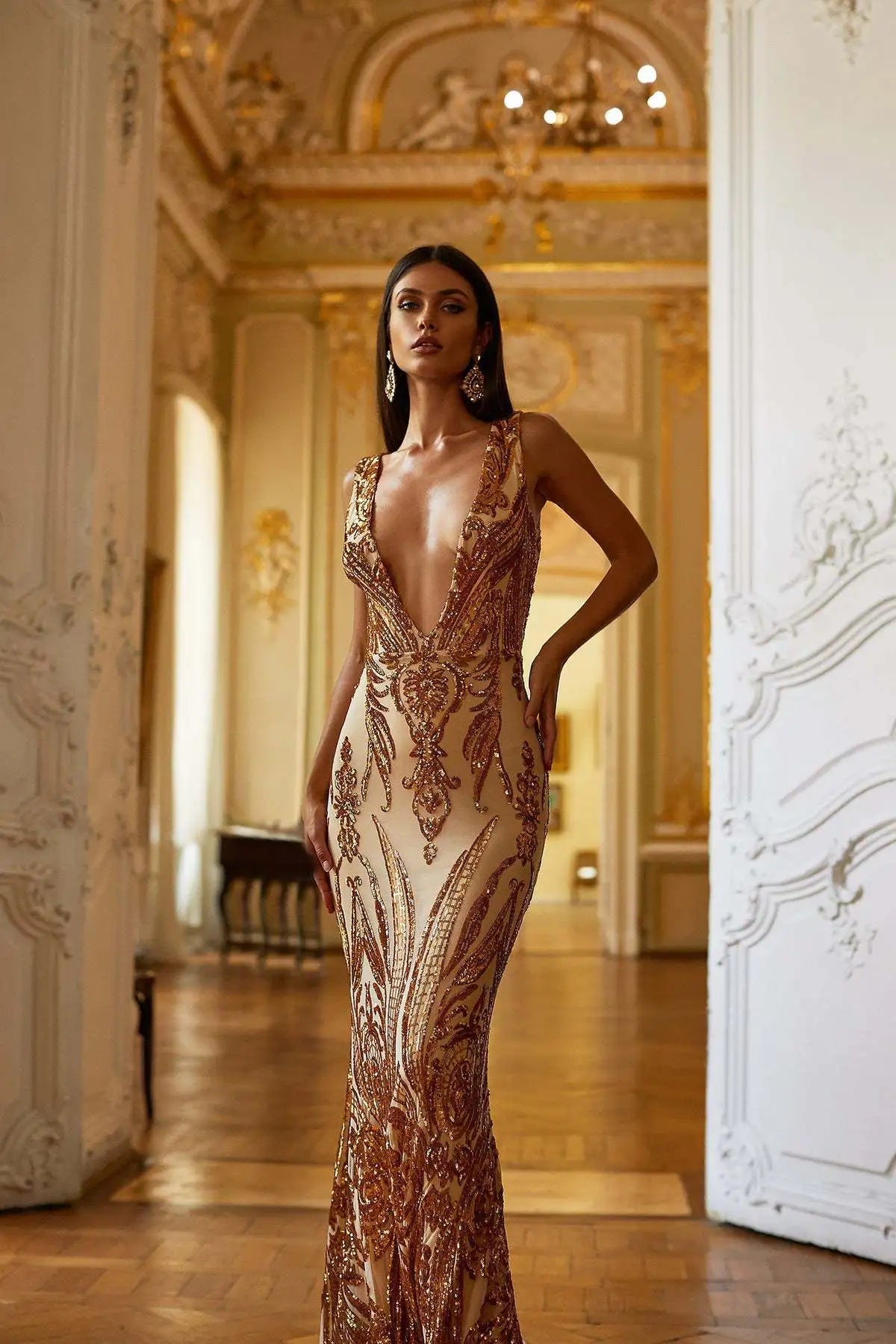 Gold sequined mermaid gown with intricate embroidery and plunging neckline.